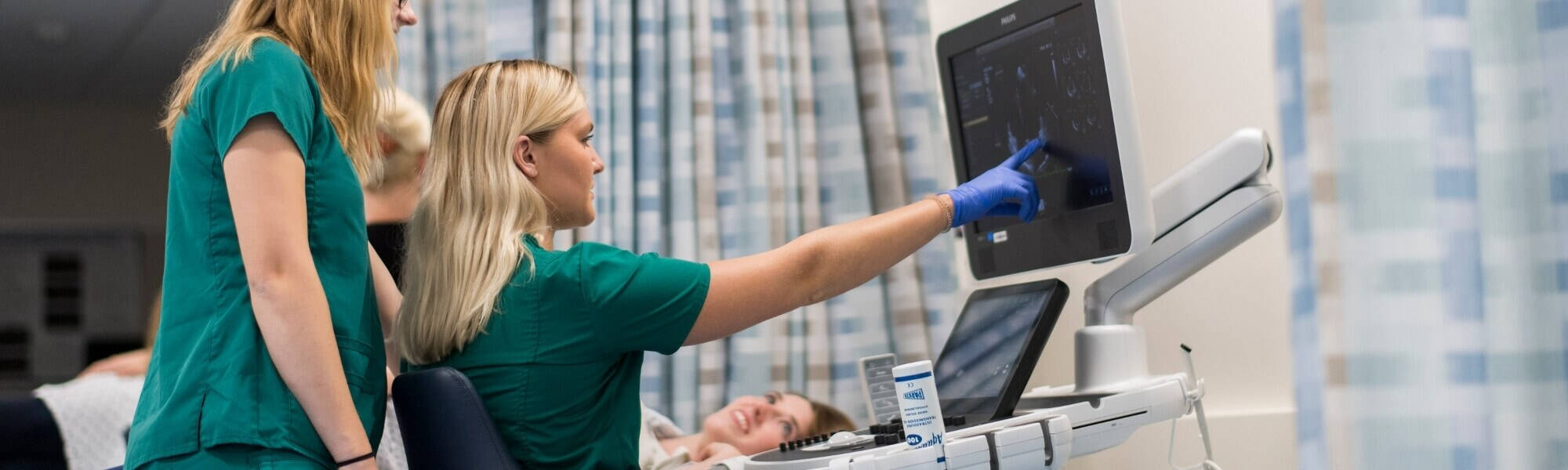 Female student pointing at monitor in the lab